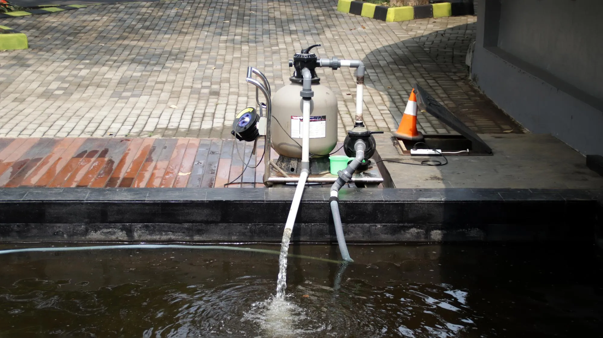 A clogged catch basin with leaves and trash obstructing water flow.