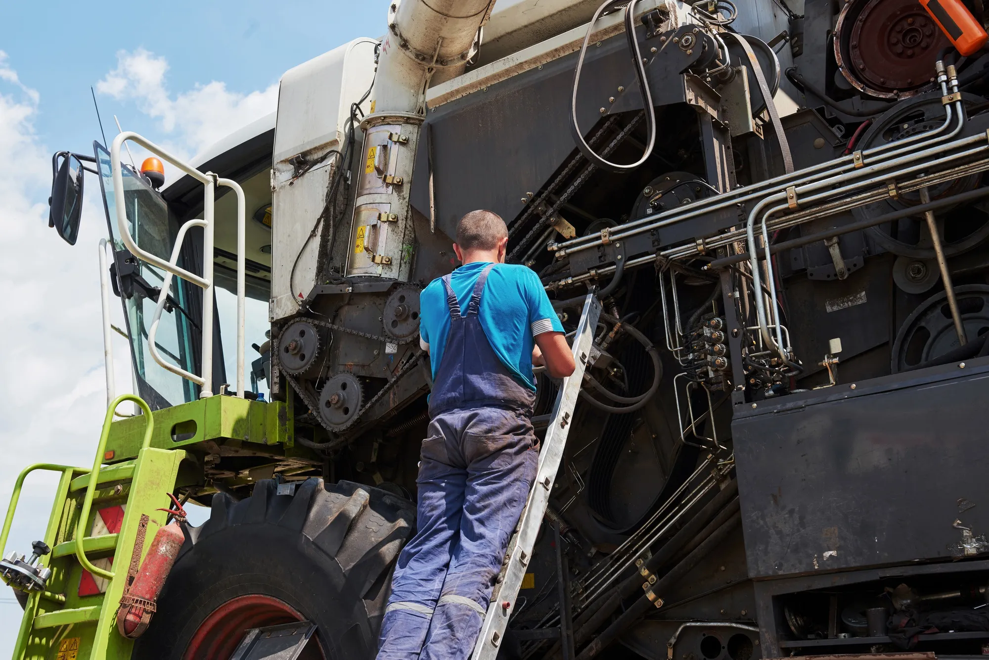 A worker manually washing a truck with a sponge and hose.