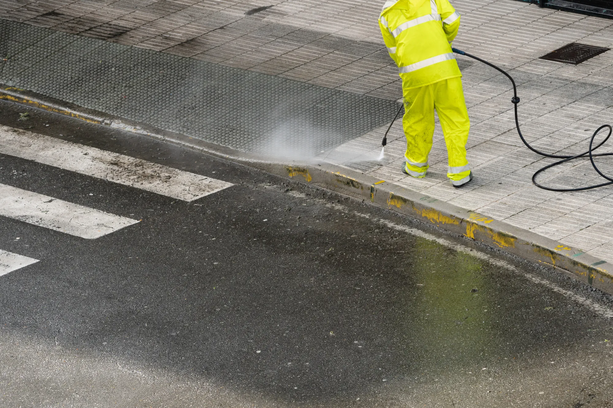 Oil stains and debris on an underground parkade floor before cleaning.