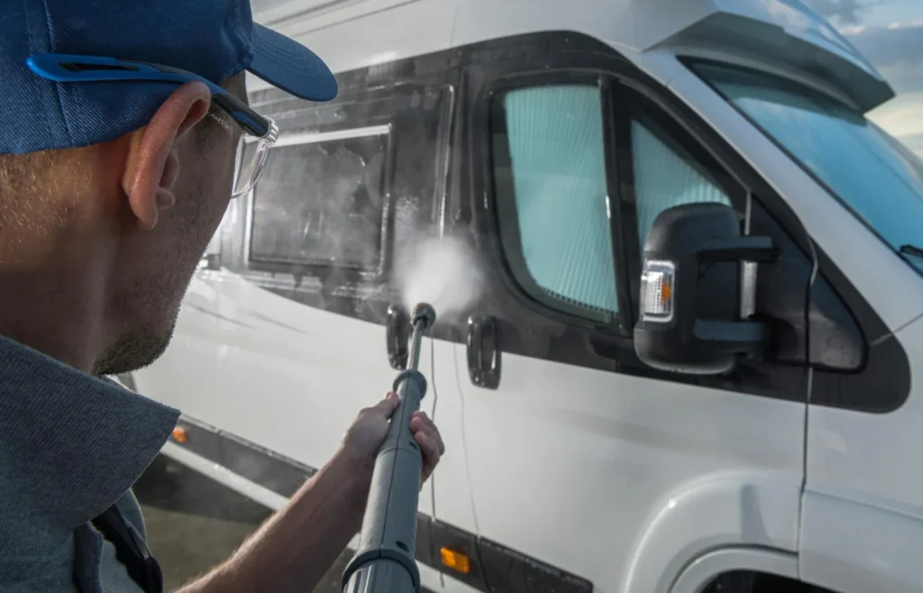 A professional team pressure washing a commercial truck fleet on-site