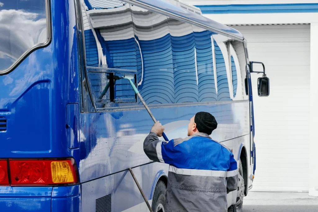 A fleet of trucks being cleaned by professional washing equipment.