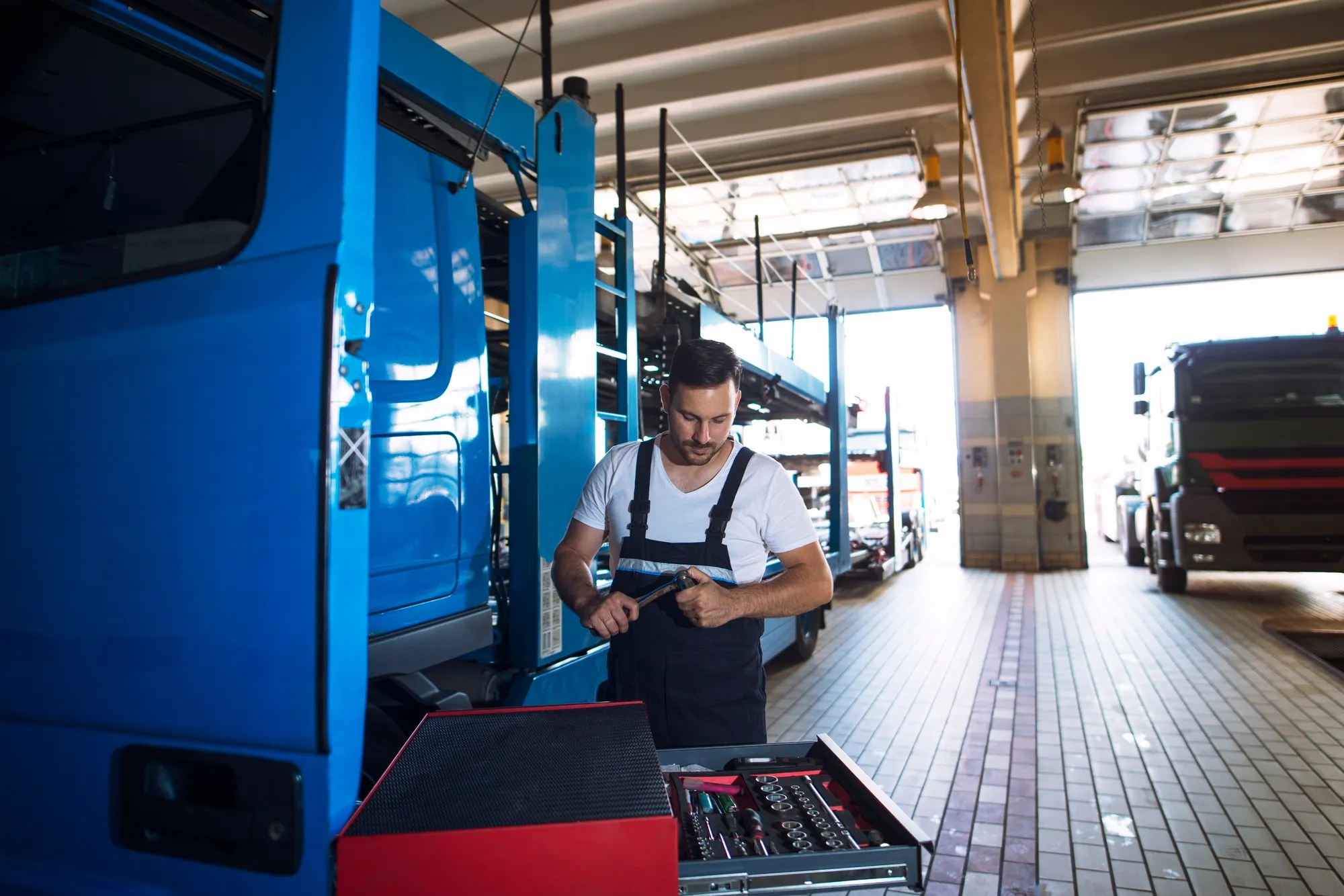 Technicians pressure washing the undercarriage of a truck for rust prevention